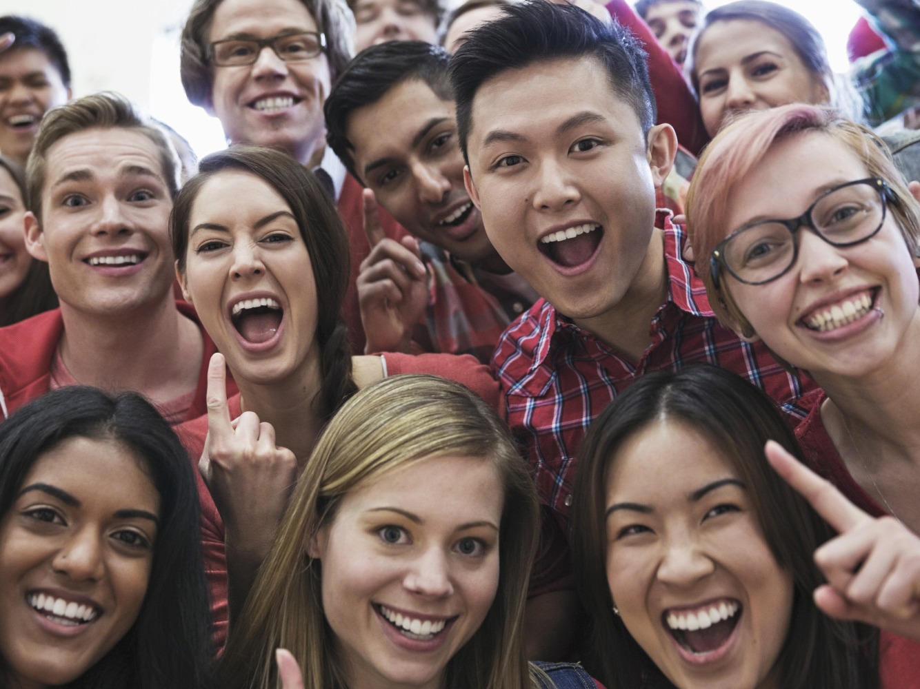 Portrait of large group of students cheering at college sporting event